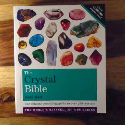 A soft cover copy of The Crystal Bible book, volume one. by Judy Hall (the original best selling guide to over 200 crystals.