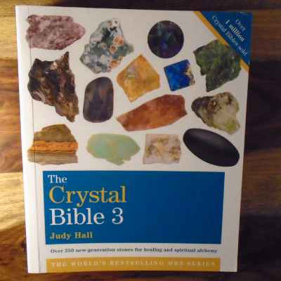 A soft cover copy of the Crystal Bible volume 3 by Judy Hall. top right corner of cover states that over 1 million copies have sold world wide. "over 250 new- generation stones for healing and spiritual alchemy"