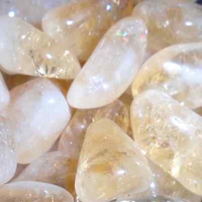 a close up of citrine tumblestones, golden yellow shading to white - a form of quartz