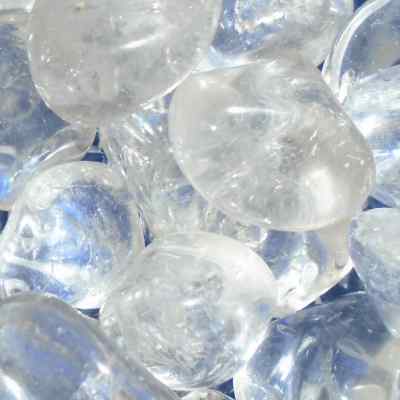 a close up of clear quartz tumble stones looking like ice against a blue background