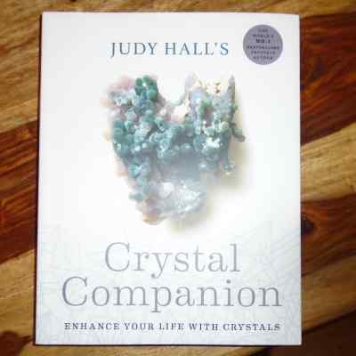 a soft cover copy of The Crystal Companion. A book by Judy Hall about gemstone and crystal healing. (enhance your life with crystals)